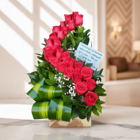 Arreglo Floral con Rosas Voluta: Elegancia y Frescura para Regalar Arreglo floral premium con rosas rojas voluta, follaje verde y detalles blancos, sobre una superficie de mármol en un entorno