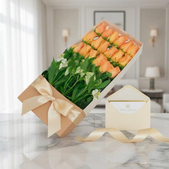 Caja de 18 rosas salmón frescas con follaje verde, presentada en una caja beige con lazo de satén y tarjeta de regalo en un s