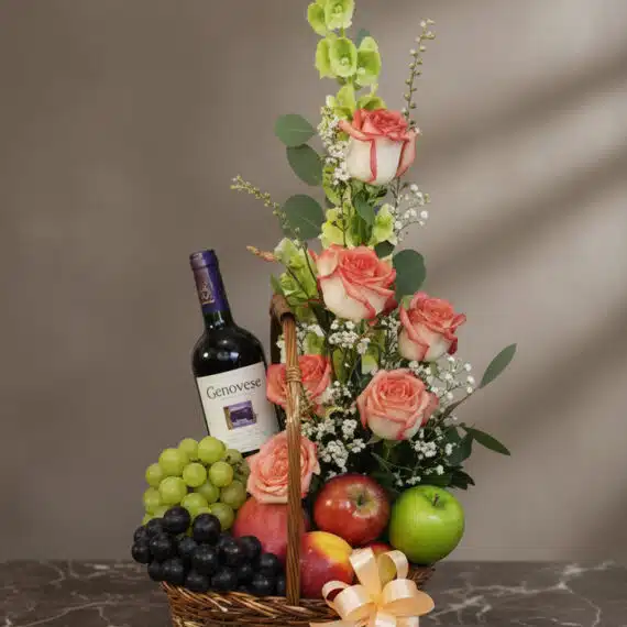 Cesta Gourmet CAPRICE: Rosas Frescas, Frutas y Vino Cesta gourmet CAPRICE con rosas frescas, uvas verdes y negras, manzanas rojas y verdes, duraznos y una botella de vino tinto